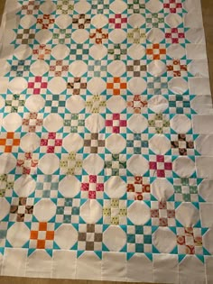 a quilted table topper with many different colored squares and circles on it's surface