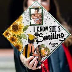 a woman holding a graduation cap with pictures on it and the words i know she's smiling