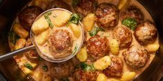 a bowl filled with meatballs and potatoes next to a ladle full of sauce