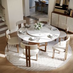 a dining room table with chairs and plates on top of it in front of stairs