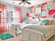 two beds in a bedroom with floral wallpaper and curtains on the windowsills