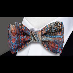 Brown, Red, Orange, Light Blue Paisley Self-Tie Bow Tie Picture yourself wearing a luxurious paisley silk bow tie and accenting silk pocket square, crafted from the finest materials and bursting with rich, vibrant colors. The intricate paisley pattern features shades of brown, red, orange, and light blue, creating a mesmerizing effect that draws the eye and exudes a sense of sophistication and style. To showcase this stunning bow tie, pair it with a crisp white or light blue dress shirt. The con Orange And Light Blue, Clean Background, Charcoal Gray Suit, Light Blue Dress Shirt, Dark Suit, Paisley Color, Blue Dress Shirt, Tie Matching, Light Blue Dress