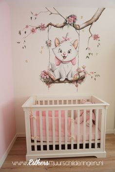 a baby's room with a white crib and wall mural featuring a cat on a tree branch