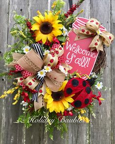 a welcome wreath with sunflowers, daisies and ladybug on it