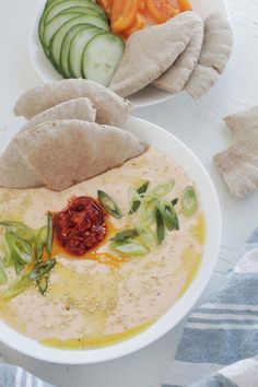 a bowl of hummus, cucumbers and tomatoes