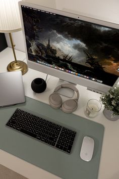 a desktop computer sitting on top of a desk next to a keyboard and headphones