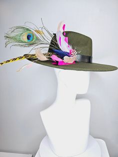 The Hat Doctor From the 2024 Featured Milliner of the Kentucky Derby Museum  kentucky derby hat wide brim olive green felt fedora rancher hat with colorful feather and stunning vegan leather and gold horsebit  decor each hat is totally one of a kind! no two are alike! I can probably add feathers, flowers etc to existing hats for a small fee. I cannot remove anything from existing hats. Just message me and see if we can make it work! :) I cannot make custom order from scratch. My schedule is unfo Crazy Kentucky Derby Hats, Diy Leather Hat, Derby Fashion, Rancher Hat, Leather Hat, Kentucky Derby Hats, Derby Day, Kentucky Derby Hat, Felt Fedora