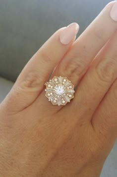 a woman's hand with a ring on it and a diamond in the middle