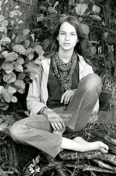 a black and white photo of a woman sitting on the ground