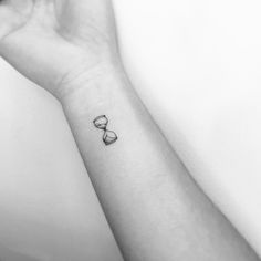 a woman's wrist with a small tattoo on the left side of her arm