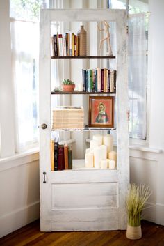 a white book shelf filled with books next to a window