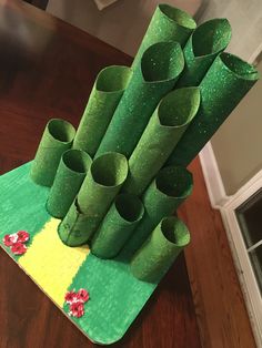 a bunch of green plastic pipes sitting on top of a wooden table