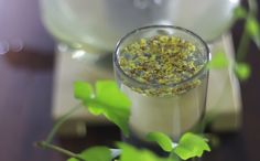 a glass filled with liquid sitting on top of a wooden table