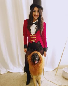 a woman standing next to a dog wearing a top hat