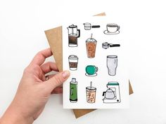 a hand holding a card with coffee related items