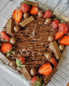 a chocolate cake with strawberries and chocolate on top