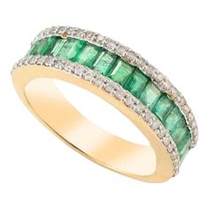 an emerald and diamond ring with two rows of diamonds on the band, set in 18k yellow gold