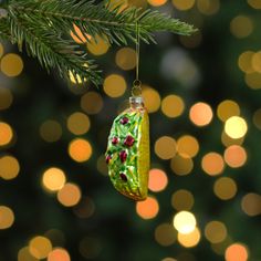 a green ornament hanging from a christmas tree