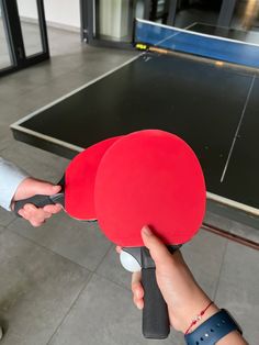 two people holding ping pong paddles in their hands