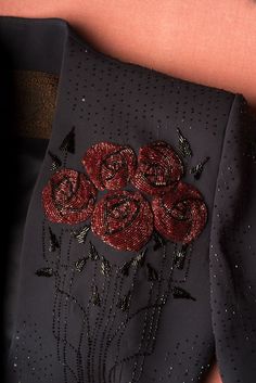 a woman's black dress with red roses on it