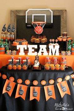 an orange and black basketball themed party with team name on the table, cupcakes and desserts