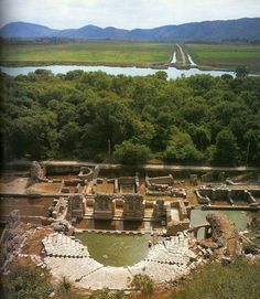 an aerial view of the ruins and surrounding trees in front of a body of water