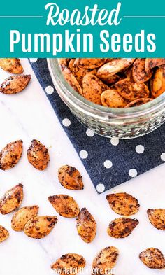 roasted pumpkin seeds in a glass bowl on top of a blue napkin with white dots