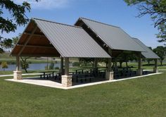 a pavilion with picnic tables in the grass