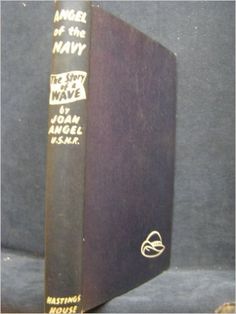 an old book sitting on top of a blue cloth covered table next to a black wall