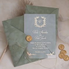 a wedding card with wax stamp on it next to some gold coins and other items