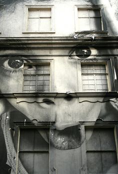 a black and white photo of a woman's face on the side of a building