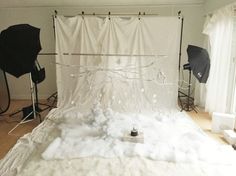 a photo studio with white foam and umbrellas on the floor in front of it