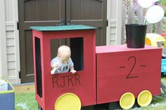 a small child in a toy train on the grass