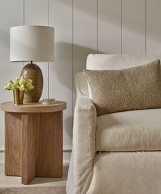 a living room with a couch, table and lamp on it's side stand