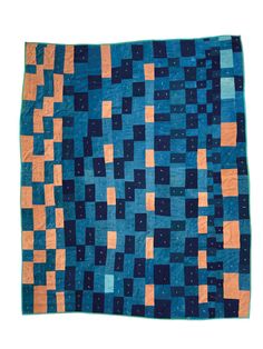 a blue, orange and black quilt with squares on the bottom in different shades of blue