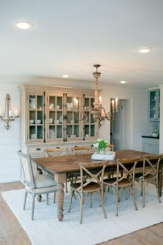 a dining room table with chairs and a chandelier in the middle of it