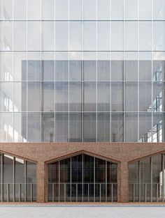 an empty parking lot in front of a tall building with lots of windows on it