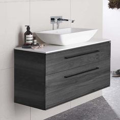 a bathroom sink sitting on top of a wooden cabinet