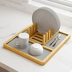 a tray with plates, cups and utensils in it