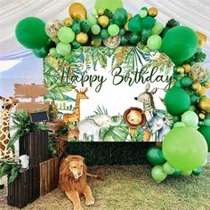 a happy birthday sign surrounded by green balloons and jungle animals, with a lion under the banner