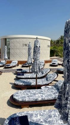 there are many lounge chairs and umbrellas on the roof top deck in front of an office building