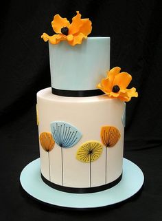 a three tiered cake with orange flowers on the top and black trimmings