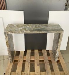 a table made out of wood pallets on top of a wooden pallet with white walls in the background