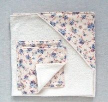 a white blanket with blue and pink flowers is folded on top of a gray surface