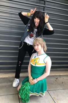 two young women posing for a photo in front of a garage door