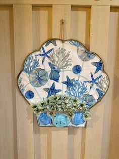 a decorative blue and white plate hanging on a wooden wall