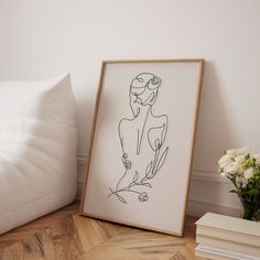 a black and white drawing sitting on top of a wooden floor next to a bed