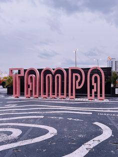 there is a large pink sign that says tampa in the middle of an empty parking lot