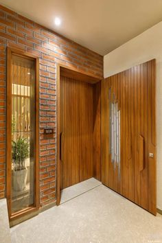 an empty room with wooden doors and brick walls