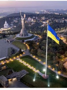 an aerial view of a city with a flag flying in the foreground at night